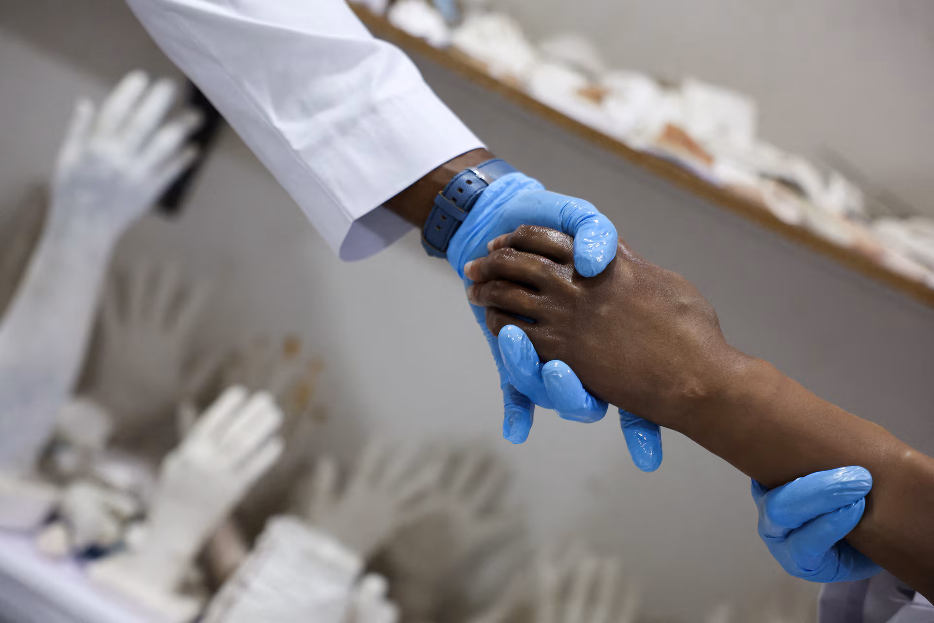 Ubokobong Amanam, 28, who lost a limb, attempts to shake hands using a flesh-like bionic arm, which he co-created with his brother John Amanam, 36, a former movie effects artist who creates custom prosthetics that match skin color, at their Immortal Cosmetic Art laboratory in Uyo, Akwa Ibom state, Nigeria, August 15, 2025. REUTERS/Sodiq Adelakun